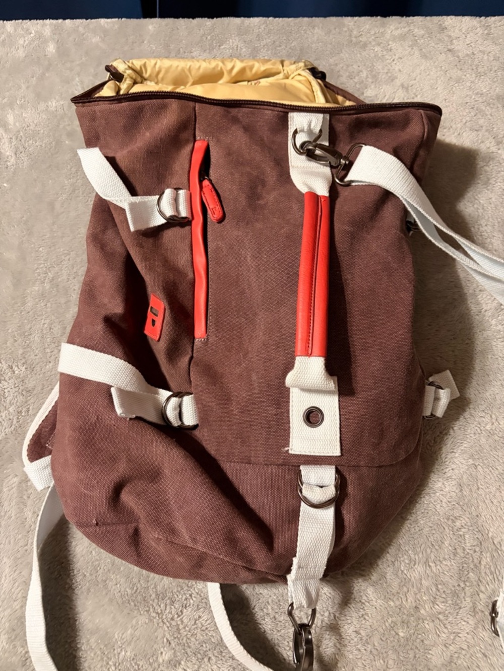 Brown Canvas Roll-Top Backpack with White Straps and Red Trim